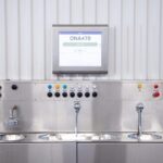 Rostfri styrpanel med touchscreen och flera knappar för programval i en självtvättsanläggning för bilar.